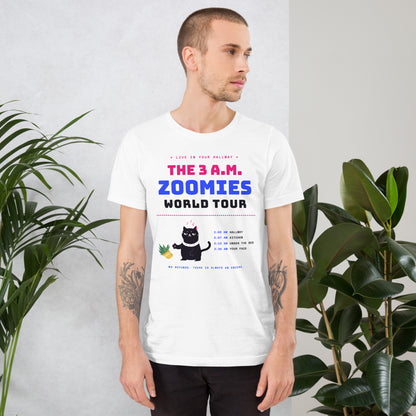 Man wearing a white unisex t-shirt with a black cat knocking over a plant and the words “The 3 A.M. Zoomies World Tour” with a list of tour stops